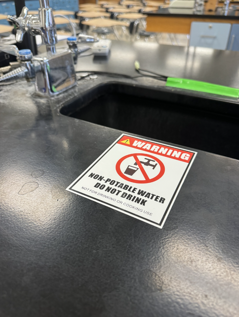 Hazard signs warn students of lead in lab stations around the high school. 